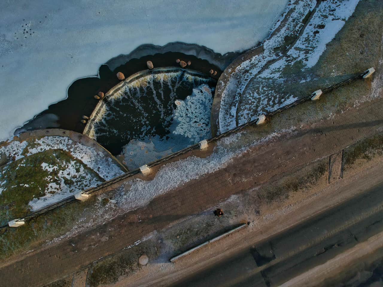 Ice melt pellets scattered across a frozen concrete walkway